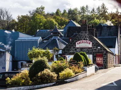 Steinerne Aberlour-Brennereigebäude mit Pagodendächern und rotem Eingang.