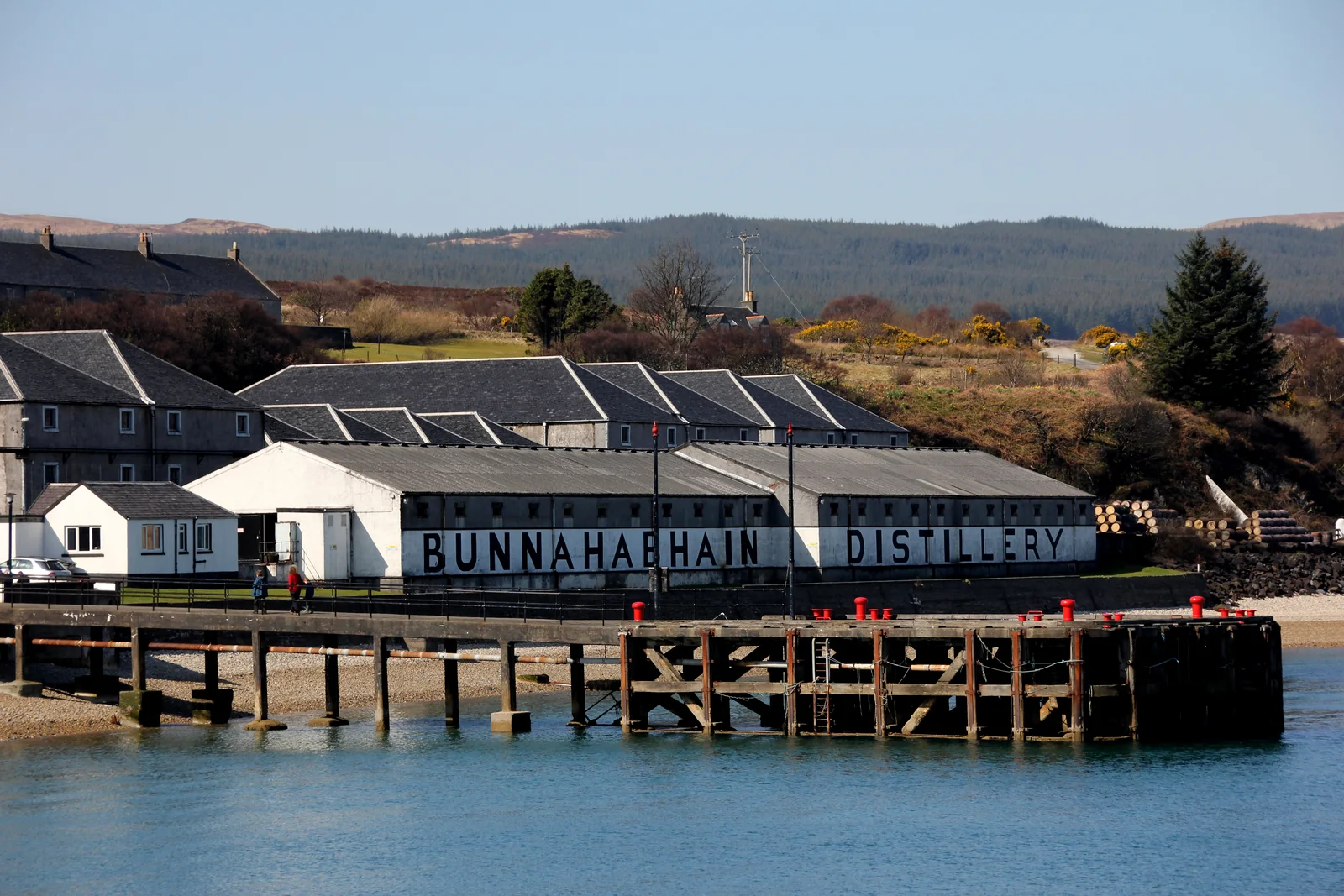 Bunnahabhain-Gebäude mit Schriftzug und Steg am Wasser.