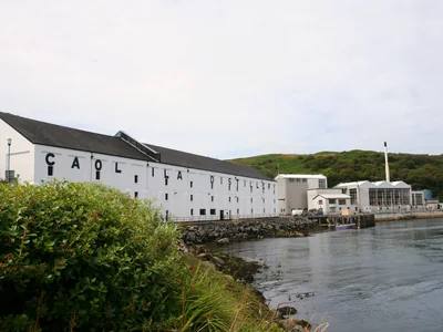 Weiße Caol-Ila-Gebäude mit Schriftzug direkt am Wasser.