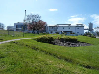 Moderne Gebäude der Clynelish-Brennerei hinter einer grünen Böschung.