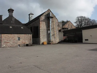 Steinerne Dalmore-Gebäude mit Pagodendach an einem Brennereihof.