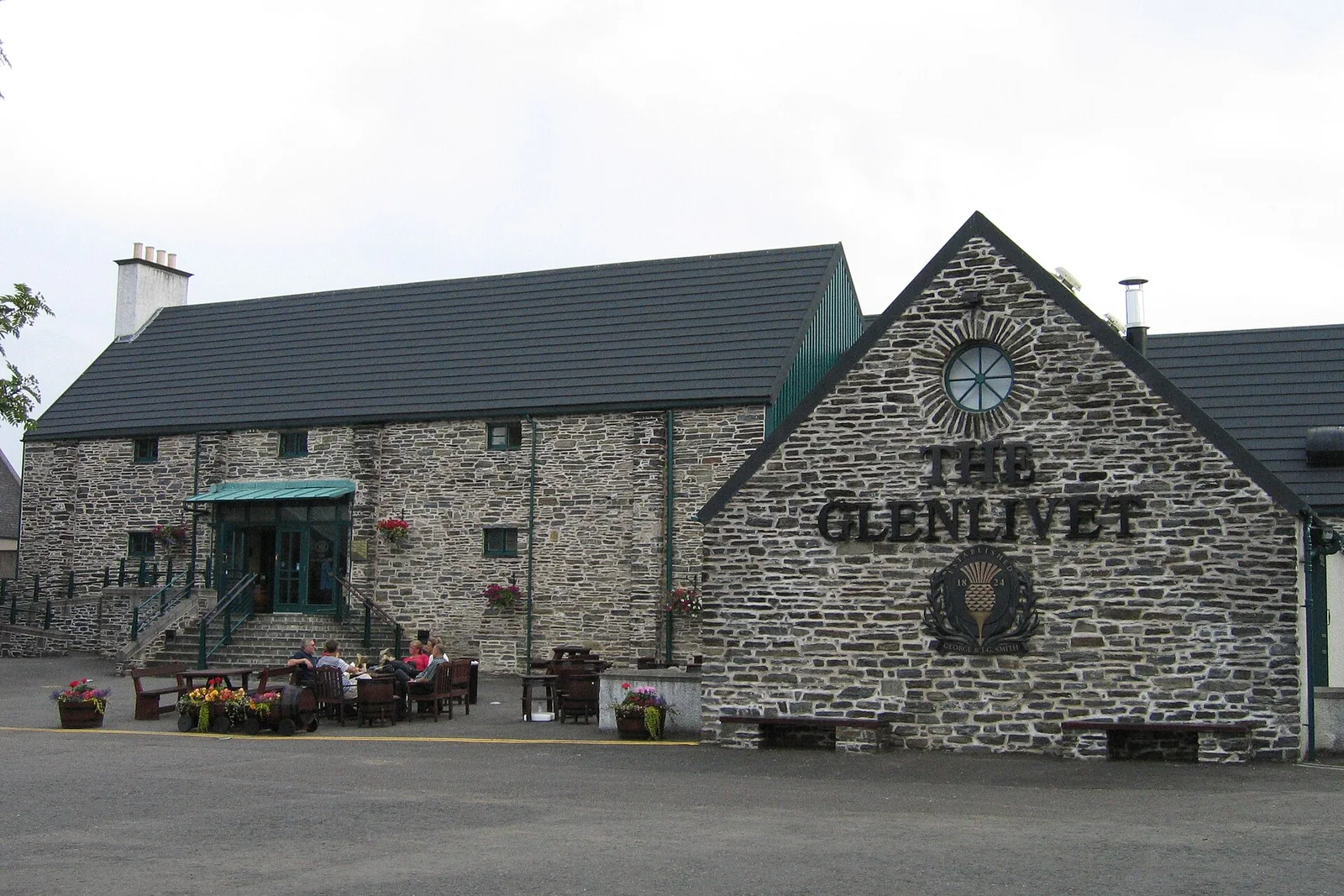 Steinernes Glenlivet-Gebäude mit Uhr im Giebel und großem Brennereischriftzug.