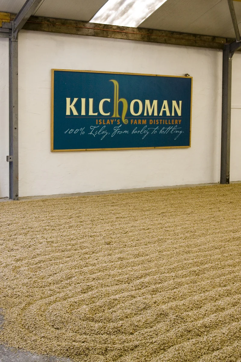 Gerste auf dem Mälzboden unter einem Kilchoman-Schild.