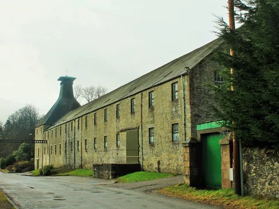 Langes steinernes Mortlach-Lagergebäude mit Pagodendach und grünem Eingang.