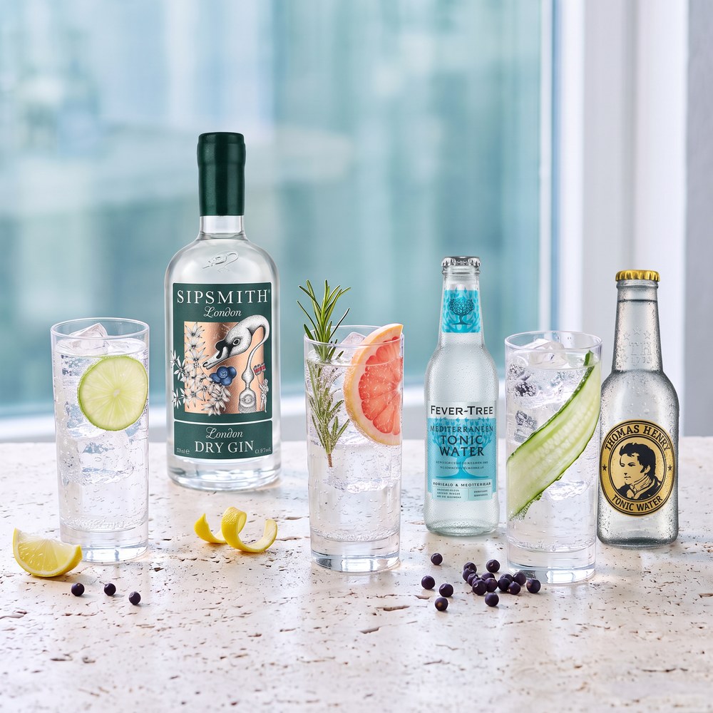 Drei Gin & Tonic mit unterschiedlicher Garnitur vor Sipsmith Gin sowie Fever-Tree und Thomas Henry Tonic Water